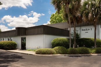 Shot of outside of the lab space, white building with a brown roof